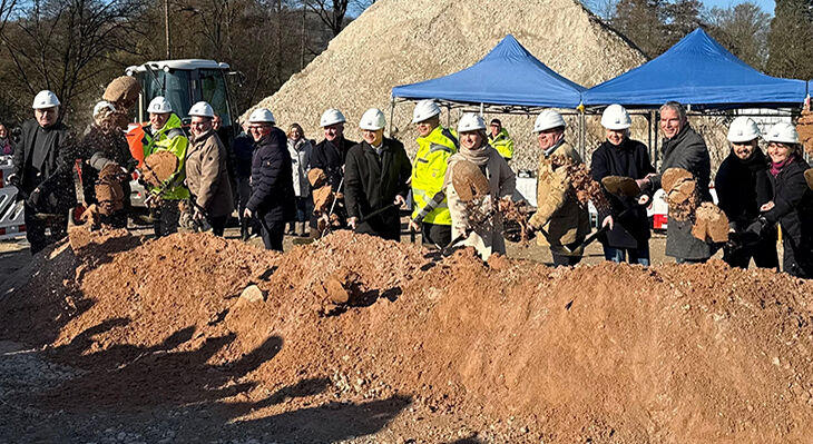 Eine Gruppe von Menschen bei einem gemeinsamen Spatenstich.