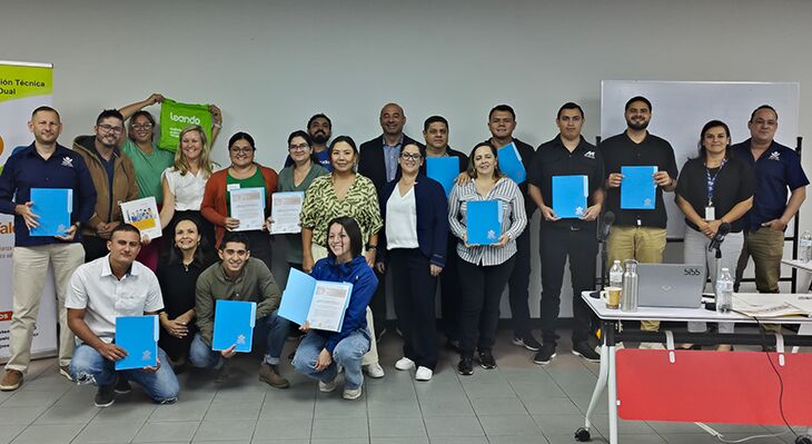 A group of workshop participants holding up documents