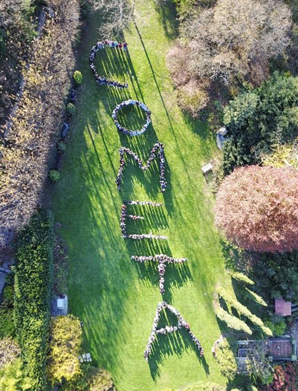 Aerial view of people forming the letters for "Cometa"