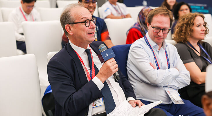 Ein Konferenzteilnehmer im dunklen Anzug spricht w&auml;hrend einer Diskussionsrunde auf der WorldSkills Conference Shanghai 2026 in ein Mikrofon.