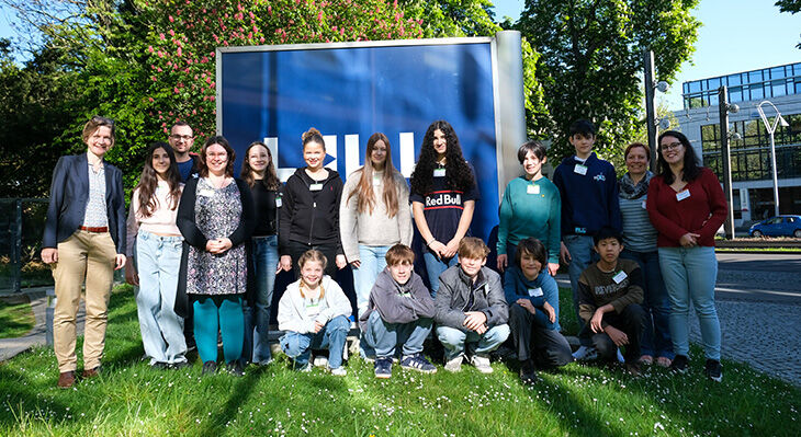 Gruppenfoto der teilnehmenden Kinder auf der Wiese vor dem BIBB-Logo