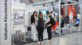 Mitarbeiterin der Intiative Klischeefrei steht am Messetand auf der didacta und ber&auml;t