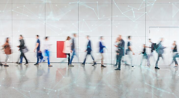 Menschen auf einem Messegang in Zeitraffer nach links oder rechts laufend