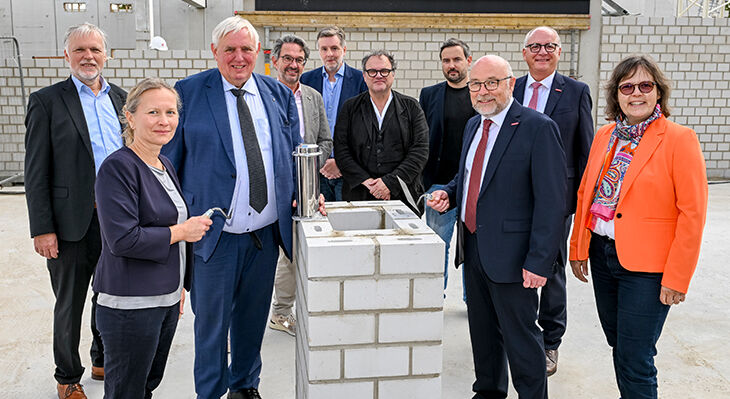 Eine Gruppe von Personen bei der Zeremonie eines Spatenstichs. 