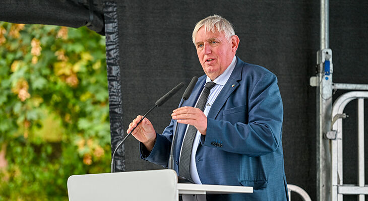 Minister Karl-Josef Laumann hält ein Grußwort auf einem Podium.