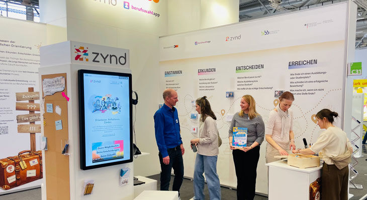 Gro&szlig;e, helle Eingangshalle mit vielen Menschen, Glasgel&auml;ndern und moderner Architektur