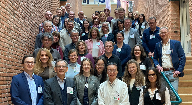 Gruppe von Teilnehmenden der Konferenz auf einer Treppe vor einer Backsteinwand, viele tragen Namensschilder.