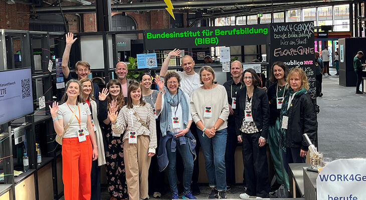 Das Team des Innovationswettbewerbs lächelt in die Kamera und winkt.