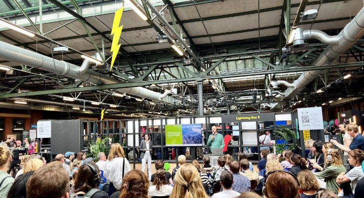 Personen vor einer Bühne während des Lightning-Talks.
