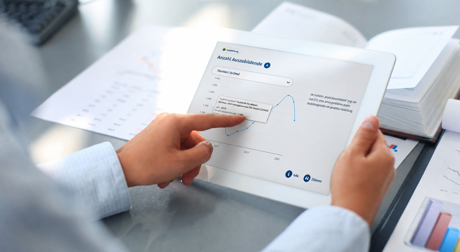Person h&auml;lt Tablet mit Diagramm und zeigt mit Finger auf einen Punkt im Diagramm