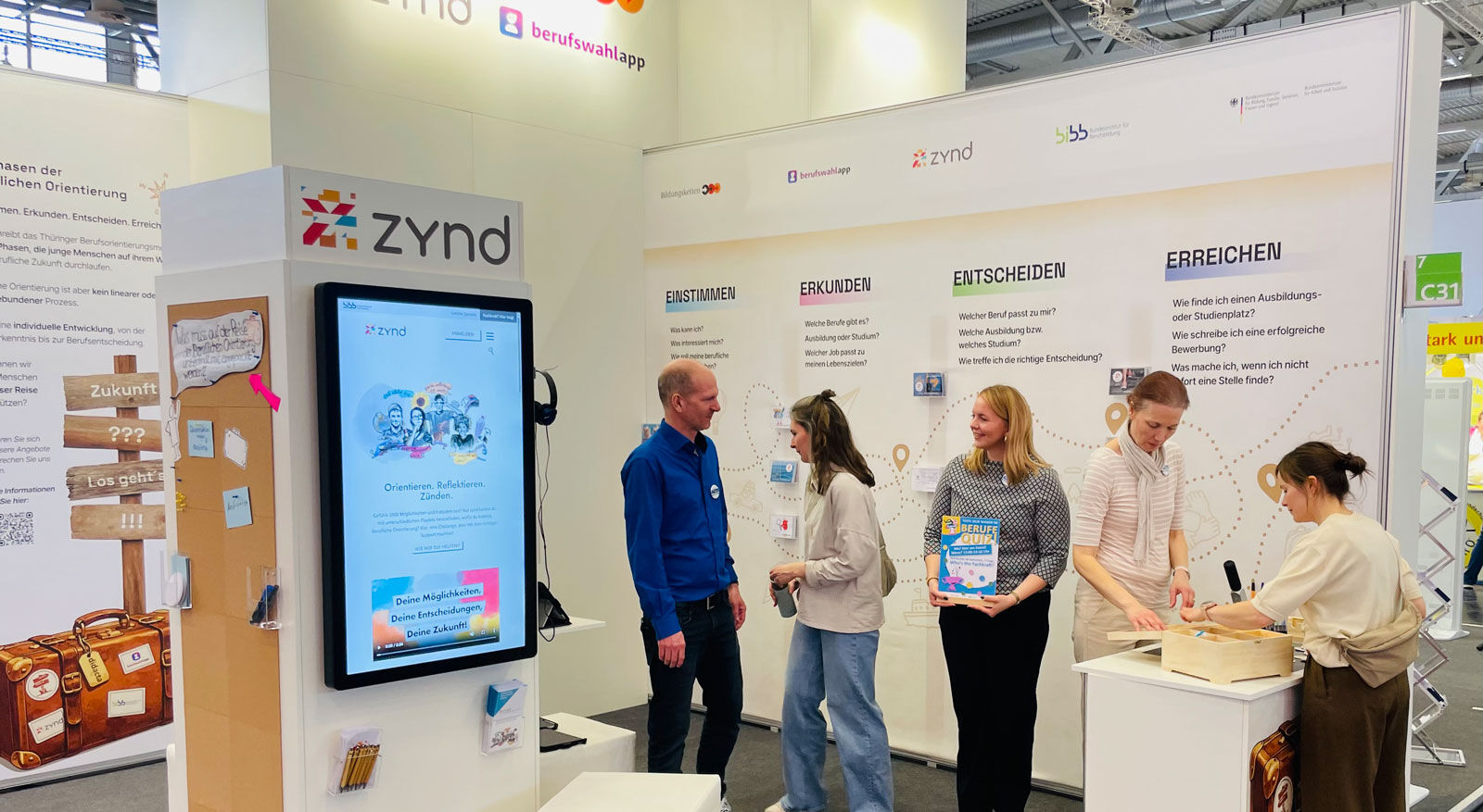 Gro&szlig;e, helle Eingangshalle mit vielen Menschen, Glasgel&auml;ndern und moderner Architektur